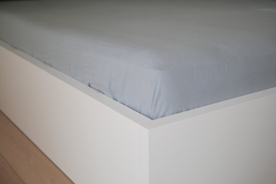 Soft bed sheet draped over a modern bed frame in a room
