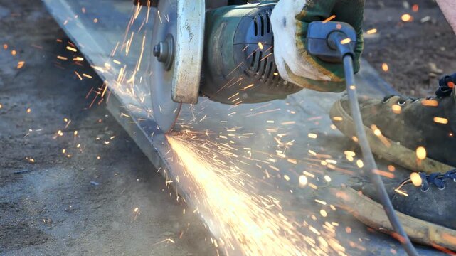 Worker using angle grinder cutting metal with sparks flying in Moscow