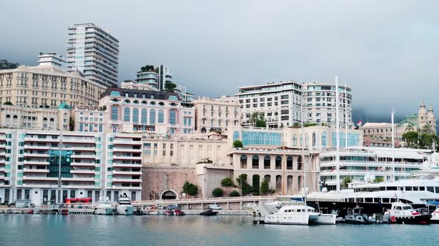 Luxury yachts moored in harbor of monte carlo with scenic architecture and foggy mountains backdrop