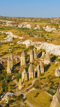 Vertical video. Goreme, Nevsehir, Turkey. Drone view of the distinctive phallic rock pillars and eroded formations that define the landscape of Gorkundere Valley.. Aerial View, MasterShots, Circle (F