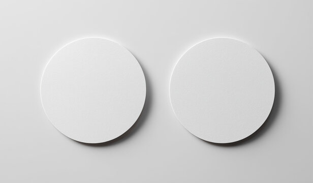 Two white round paper coasters mockup top view on minimal gray background