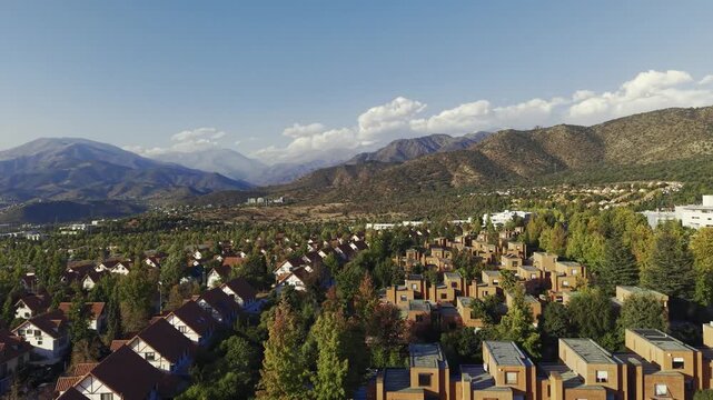 Cinematic drone sweep over a upscale neighborhood in San Carlos de Apoquindo during the golden hour. Chile, 4K
