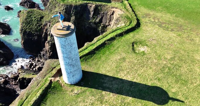 Long shadow of the Metalman tower statue pointing out to sea warning ships of danger Tramore Waterford Ireland epic locations