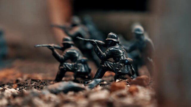 Close-up slider shot of plastic toy soldiers in a battle formation. Diorama recreating a historic conflict with detailed miniature figures