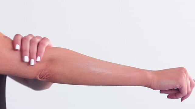 Female skincare. Arm lotion. Woman gently applying balm on palms hydrating hands elbows shoulders. Everyday treatment isolated on white.