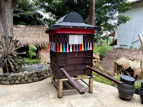 raditional Korean Palanquin Display

A dark wooden palanquin with a curved roof and colorful tassels, historically used by royalty or the upper class. Long wooden poles extend from the front for carry