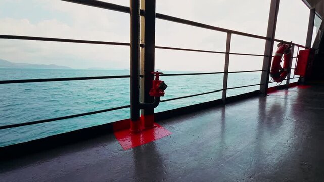 Wide View Along Ferry Deck With Red Fire Valve and Lifebuoy Near Railing Facing Open Sea and Distant Horizon, Maritime Safety And Travel Infrastructure