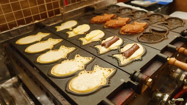 Traditional Japanese Taiyaki Fish Shaped Cakes Cooking on a Hot Griddle