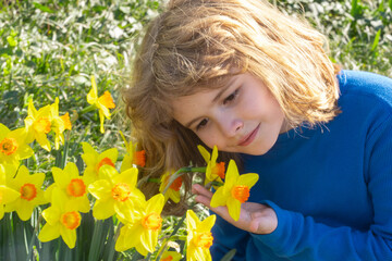 Fototapeta premium Adorable kid in spring garden. Happy childhood. Kids face near spring park. Kid Happiness. Childrens day. Cute little child under a blossom tree. Kid spring. Kids portrait in blooming cherry tree.