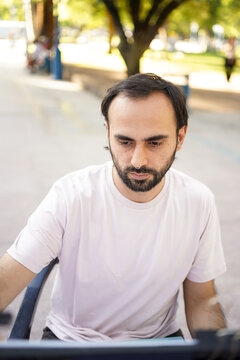 Young man drawing caricatures of people outdoors on a sunny day