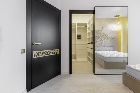 Luxury Bedroom Interior with Hidden Sliding Mirror Door and Black Designer Door