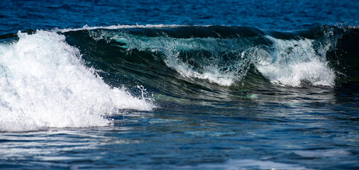 Naklejka premium Ocean waves break with white foam. Sea wave drop. Sea waves in motion. Foam forms on ocean wave. Wave sparkle. Ocean breeze with waves. Waves roll in marine.