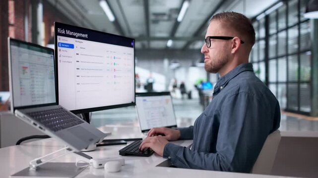 Young Man Using ERP Software On Laptop