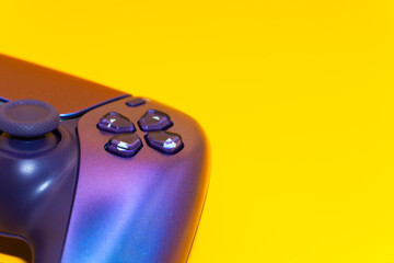 A gamepad for consoles on a yellow background, gaming addiction, gaming ban for teenagers, gaming controls for parents, for banners and advertising. High quality © Karen Vardanian