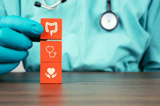 Colorectal cancer screening, colon pathology, early diagnosis, and awareness of annual checkups. The gastroenterologist's hand organizes cubes with colon and rectum icons.