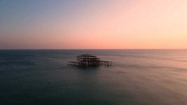 Brighton West Pier Ruins at Twilight Over Calm Sea With Pastel Sunset Sky Aerial drone view