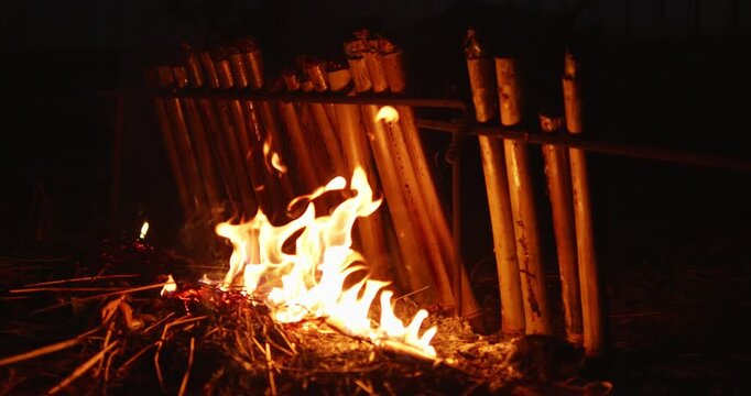 Nighttime outdoor cooking sticky rice khao lam in bamboo over fire embracing culinary traditions