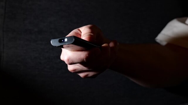 Close-Up of Man Holding Remote Control Changing TV Channels