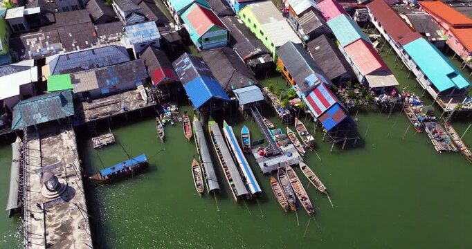 Floating Village Of Koh Panyee With Colorful Rooftops And Boats On Phang Nga Bay In Thailand. aerial pullback ascend
