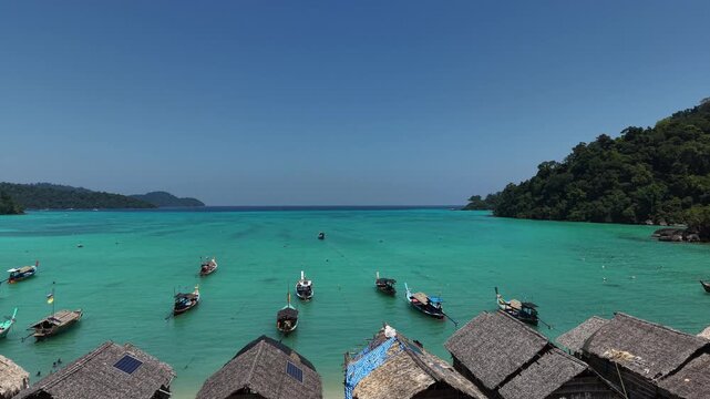 Aerial view of Ko Surin Marine National Park. Traditional long-tail boats and houses of Moken tribe Village or Sea Gypsies and tropical waters of Surin Islands in Thailand, Phang Nga.
