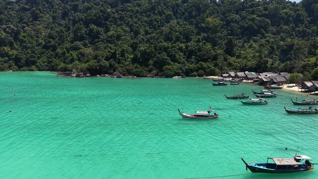 Aerial view of Ko Surin Marine National Park. Traditional long-tail boats and houses of Moken tribe Village or Sea Gypsies and tropical waters of Surin Islands in Thailand, Phang Nga.
