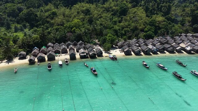 Aerial view of Ko Surin Marine National Park. Traditional long-tail boats and houses of Moken tribe Village or Sea Gypsies and tropical waters of Surin Islands in Thailand, Phang Nga.
