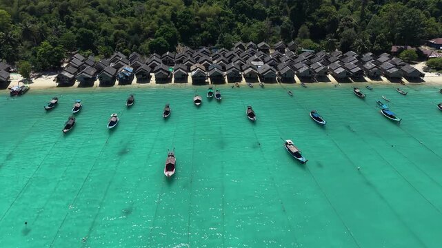Aerial view of Ko Surin Marine National Park. Traditional long-tail boats and houses of Moken tribe Village or Sea Gypsies and tropical waters of Surin Islands in Thailand, Phang Nga.
