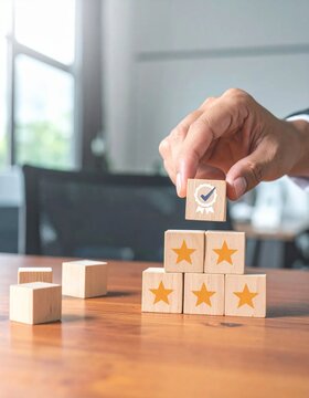 Hand placing a quality check block on top of a pyramid of five-star rating blocks, symbolizing excellent service and customer satisfaction.
