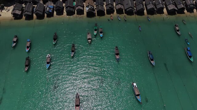 Aerial view of Ko Surin Marine National Park. Traditional long-tail boats and houses of Moken tribe Village or Sea Gypsies and tropical waters of Surin Islands in Thailand, Phang Nga.
