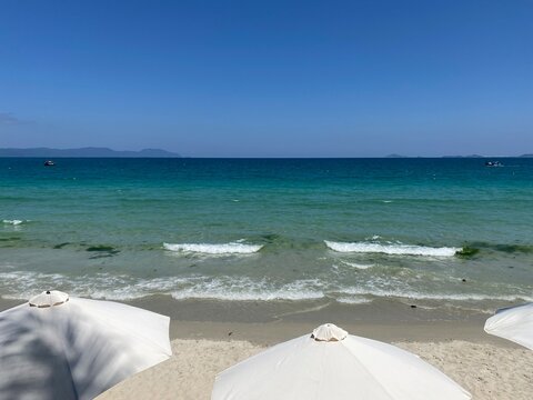 Tropical beach with umbrellas and waves 