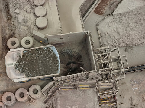 Aerial view of material unloading at primary crusher with CAEX mining dump truck