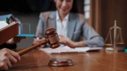 Real estate auction concept: gavel striking on model house atop laptop, with negotiators and scales...