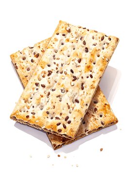 A stack of two rectangular, crispy, golden-brown flatbreads with holes