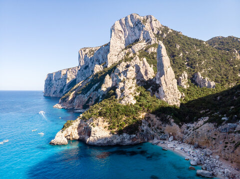 Discover the breathtaking cliffs and turquoise waters of Baunei, Sardinia, where nature's beauty invites travelers for unforgettable moments of relaxation and adventure in Italy's stunning landscape.