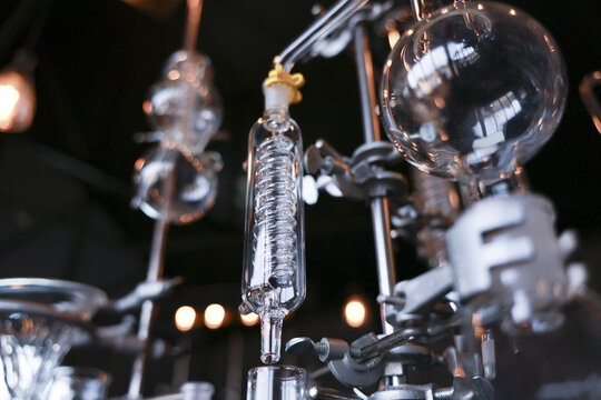 Intricate glass chemistry laboratory apparatus equipment featuring distillation condenser flask test tube setup displaying fascinating scientific experiment preparation