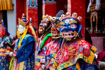 Obraz premium Buddhist monks in vibrant masks and ornate robes perform traditional Cham dance in Ladakh India showcasing spiritual ritual culture and Himalayan heritage.