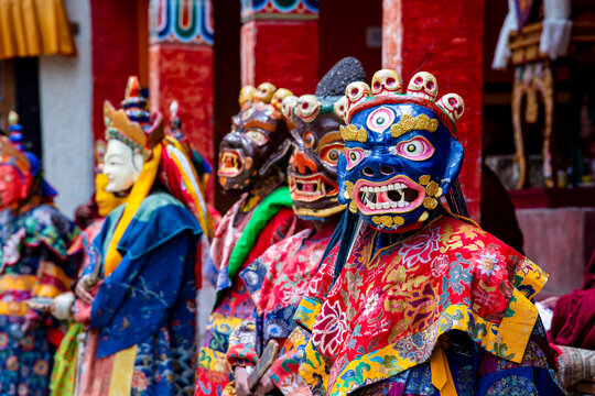 Buddhist monks in vibrant masks and ornate robes perform traditional Cham dance in Ladakh India showcasing spiritual ritual culture and Himalayan heritage.