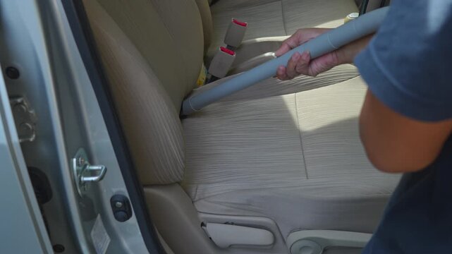 People using vacuum cleaner to clean mpv car interior, warn morning light, natural background
