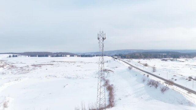 Telecommunication Tower Infrastructure Next To A Road In A Frozen Winter Landscape, Tilting Aerial Shot.