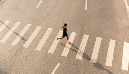 Athlete run over crosswalk top view Healthy lifestyle Urban exercise © Q88