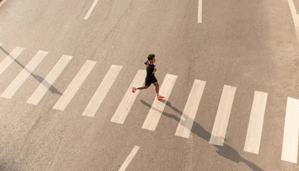Fotobehang Hardlopen Athlete run over crosswalk top view Healthy lifestyle Urban exercise  © Q88
