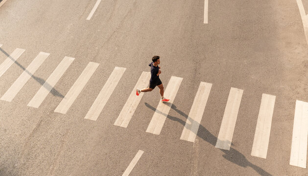 Athlete run over crosswalk top view Healthy lifestyle Urban exercise