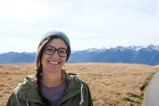 Young woman smiling with rugged snow covered mountains