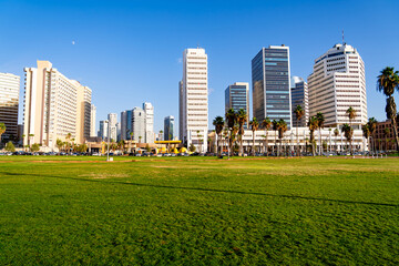 Fototapeta premium Skyscrapers on Tel Aviv waterfront with green square and palms. Popular tourist destination in Israel.