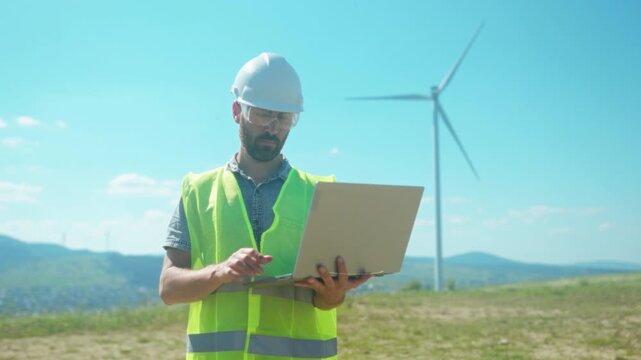 Skilled engineer monitors renewable energy performance, Technician in safety gear examines live energy production data