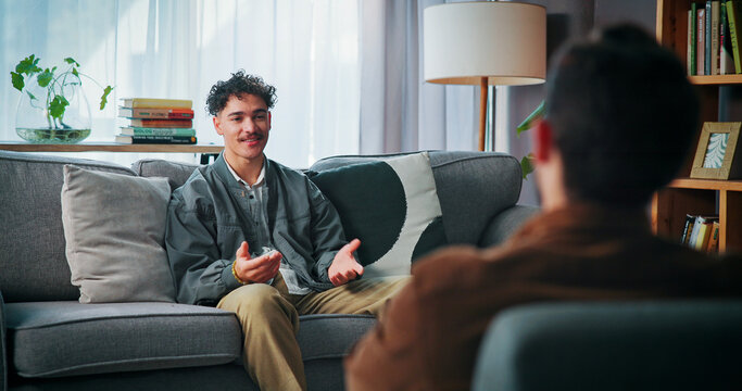 Talking, sofa and man with psychologist in office for advice, help or life coaching session. Mental health, consulting and therapist with male patient for emotional support, wellness or conversation.