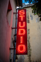 Obraz premium Red Neon Studio Sign on Building Facade