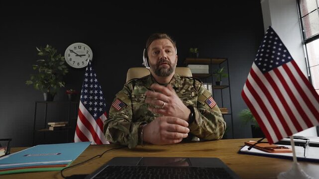 POV of American intelligence officer in headset having video call on laptop