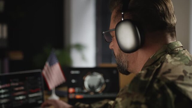 U.S. male military in headset planning operation, collecting intelligence data