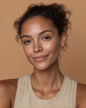 Calm mixed-race female wellness coach in activewear on sand background